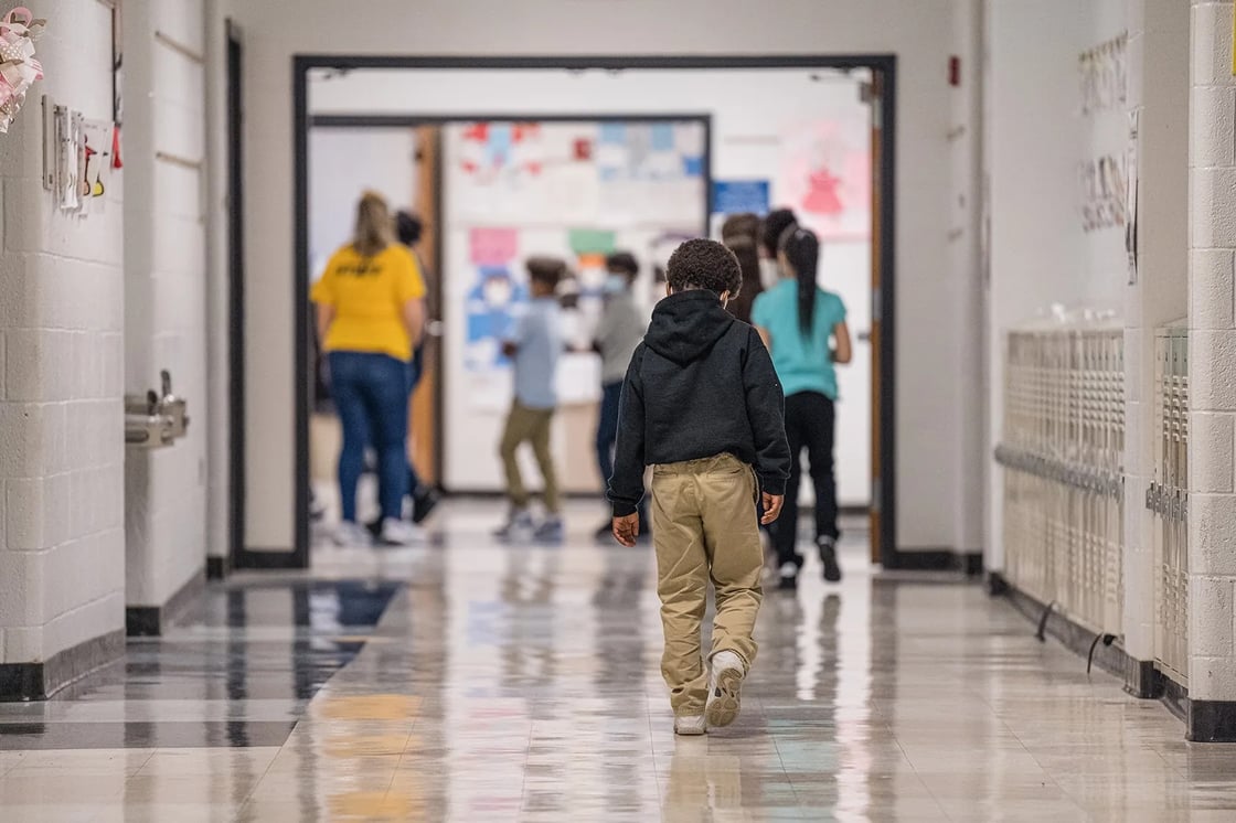 A young boy walks down a hallway at Carter Traditional Elementary School in Louisville, Kentucky, on January 24, 2022. (Getty/Jon Cherry)
