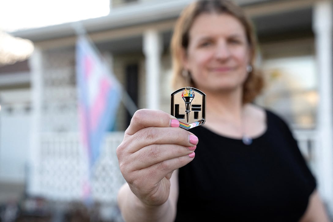 Col. Bree Fram holds a “LIT” challenge coin from the LGBTQ initiatives team, which she co-leads at her home in Reston, Virginia, March 9, 2025. (Getty/AFP/Daniel Woolfolk)