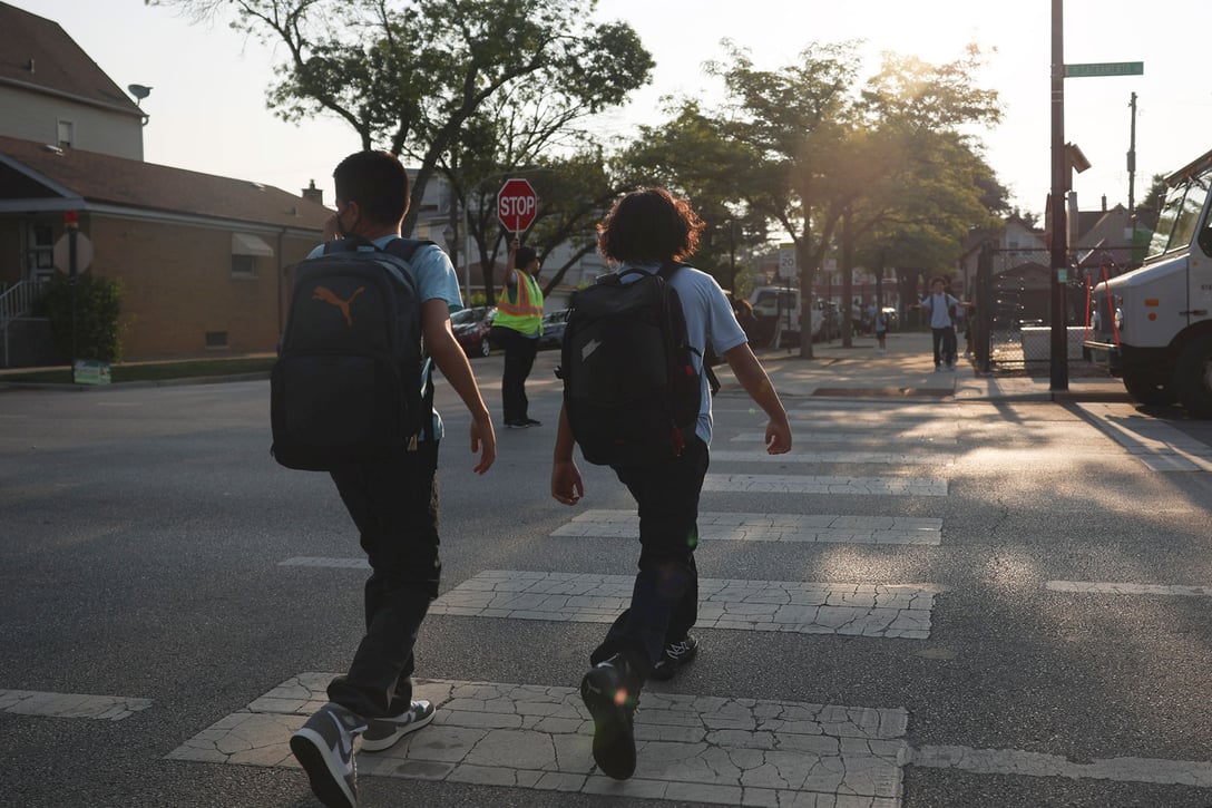Two children cross the street on the first day of school at Carl Von Linne Elementary in Chicago, Illinois, August 21, 2023. (Getty/Talia Sprague/Chicago Tribune)