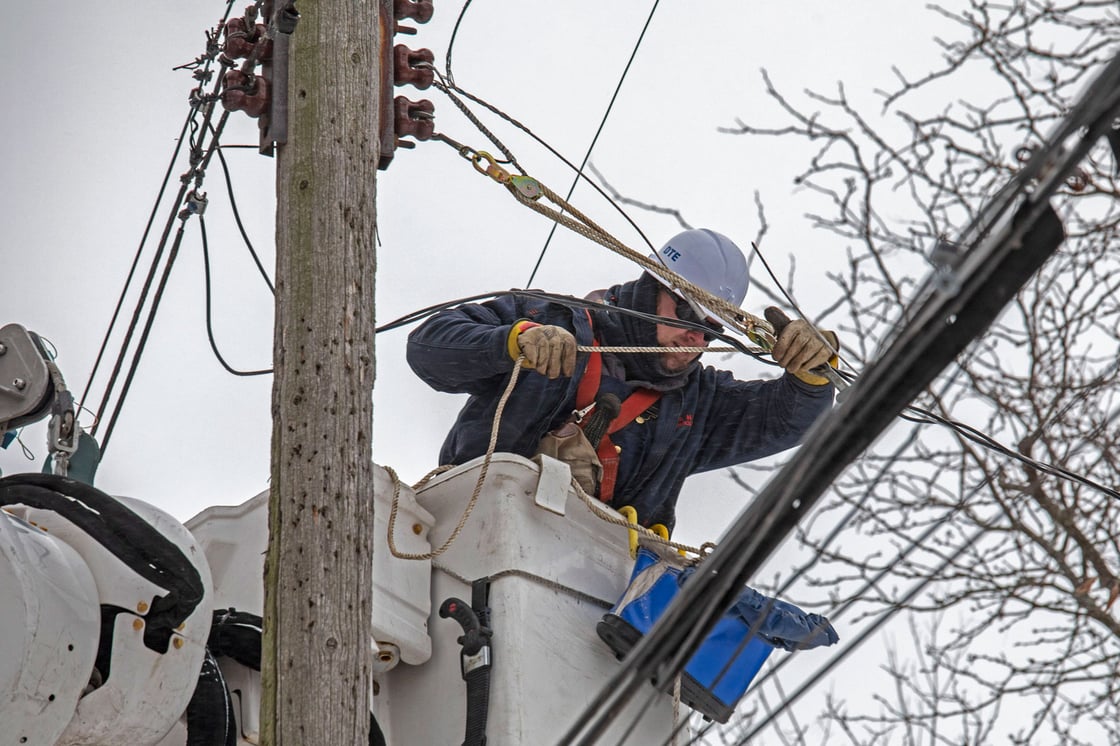 A DTE Energy worker repairs a power line taken down by a falling tree during a winter storm in Detroit on December 23, 2022. (Getty/Jim West/UCG/Universal Images Group)