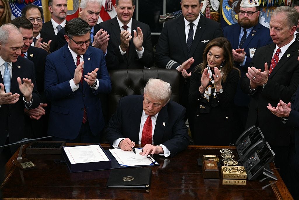 President Donald Trump signs the bill to reopen the federal government in the Oval Office of the White House in Washington, D.C., on November 12, 2025. (Photo by BRENDAN SMIALOWSKI/AFP via Getty Images)