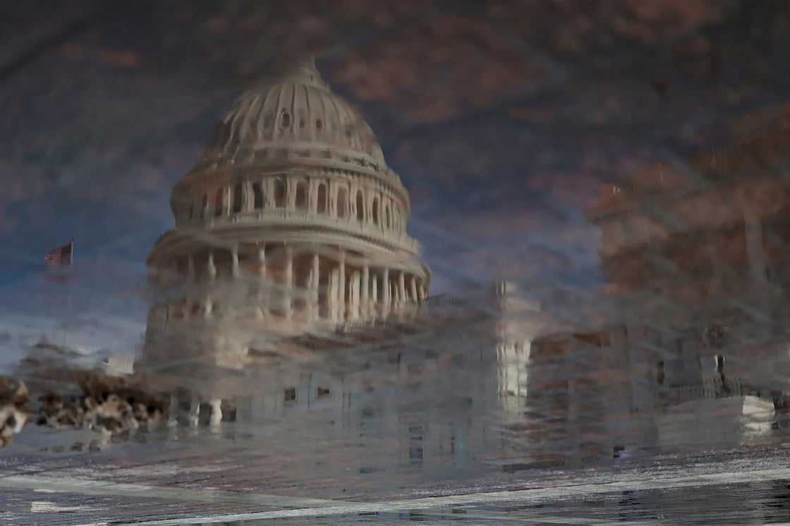 The U.S. Capitol is reflected in a puddle on January 27, 2026, in Washington. (Getty/Heather Diehl)