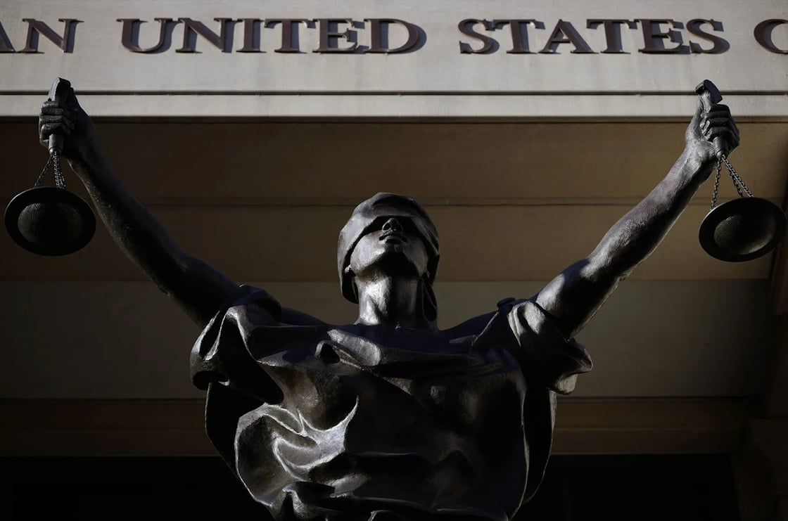 The statue titled “Justice Delayed, Justice Denied” stands on the front of the Albert V. Bryan U.S. Courthouse on November 13, 2025, in Alexandria, Virginia. ((Getty/Alex Wong))